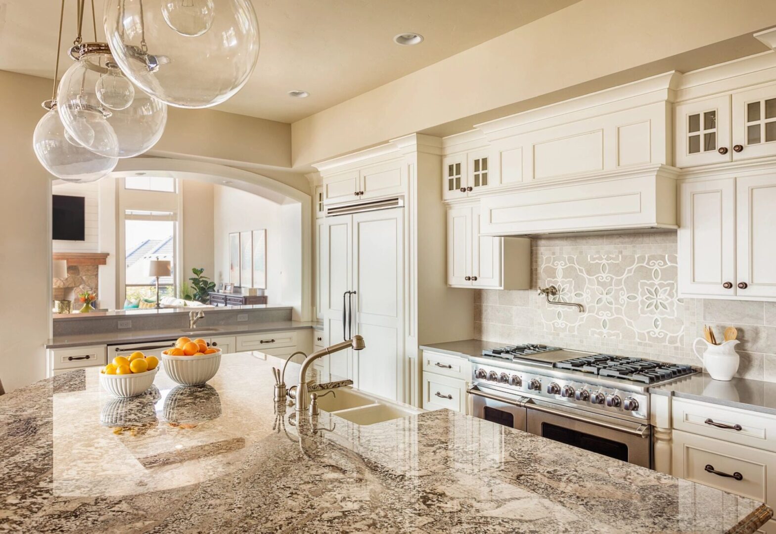 A kitchen with white cabinets and granite counter tops.